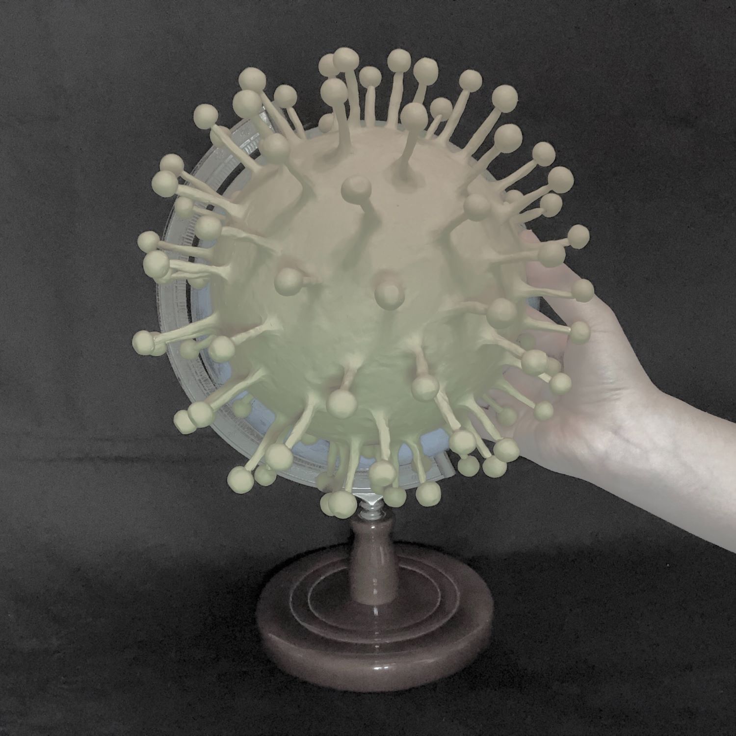 Digital image of virus cell on a stand made for a globe with hand