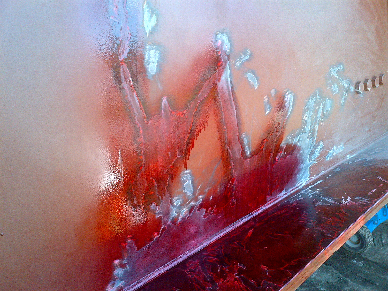 Sprayed red paint daubs on metal surface