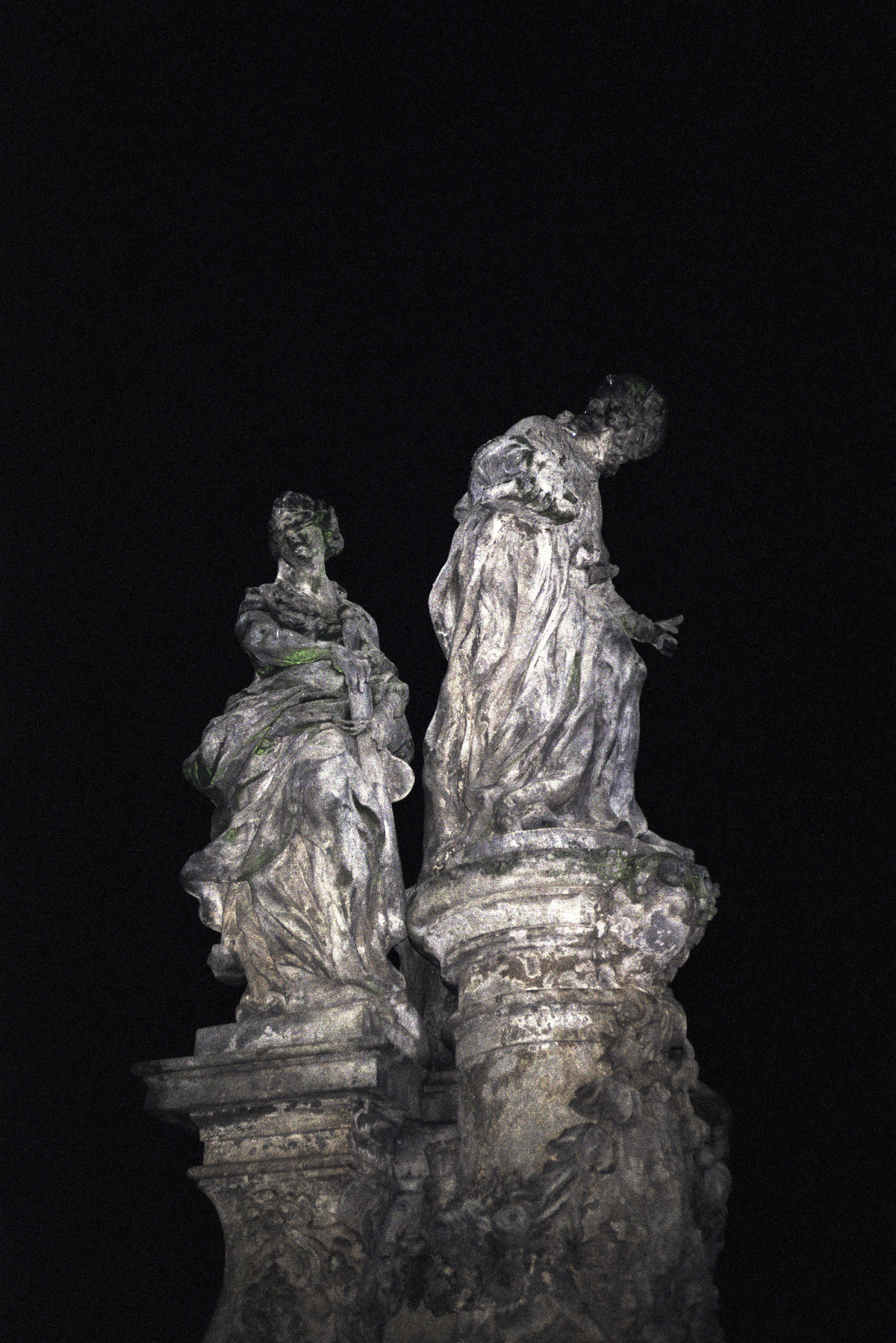 photo f two statues in a dark space