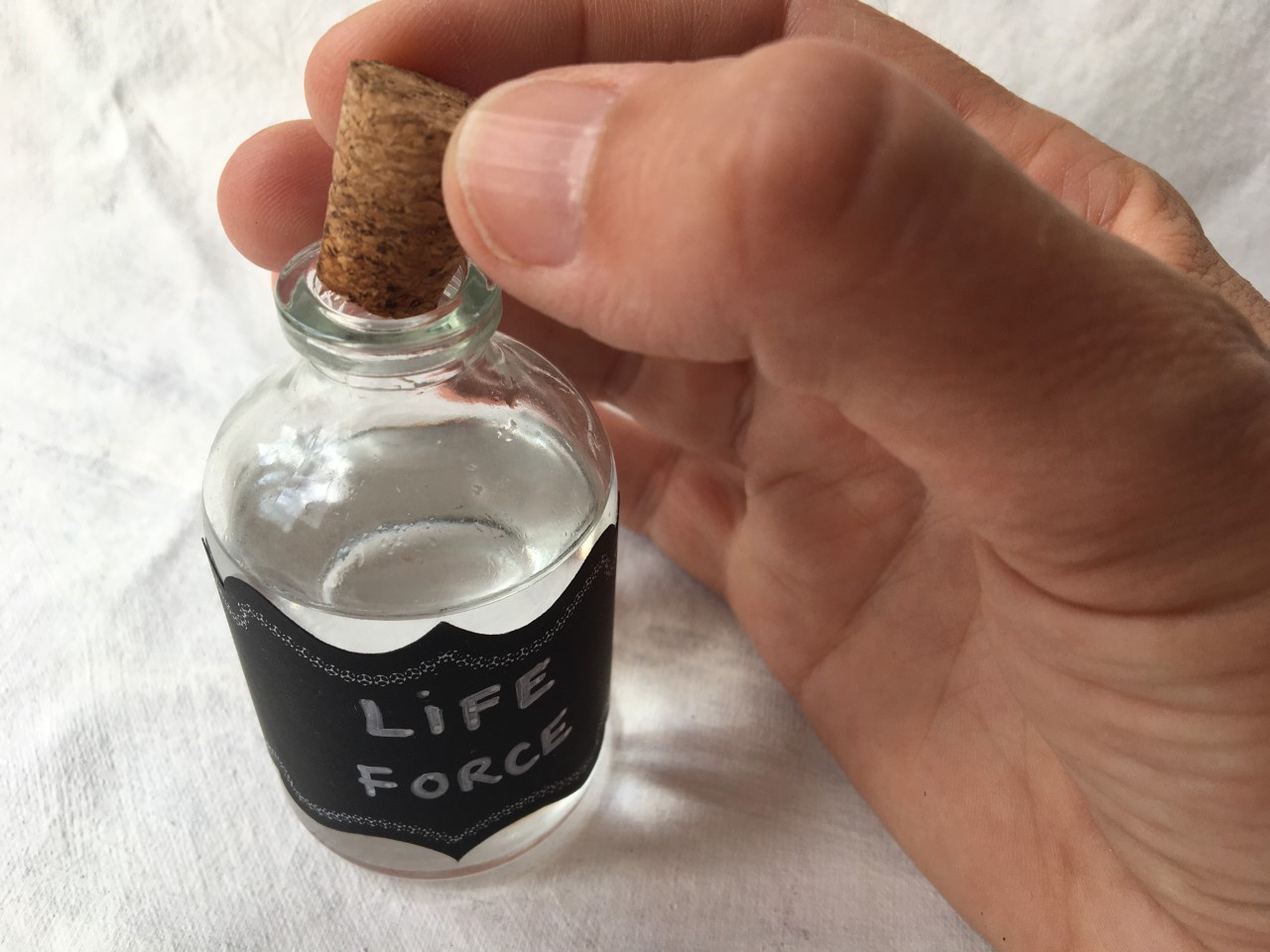 hand taking cork out of bottle